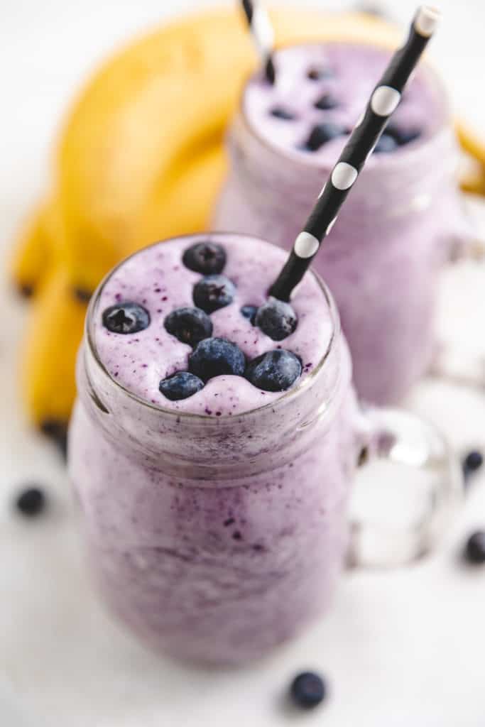 Blueberry smoothie with a black straw.