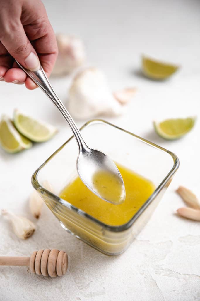 Garlic lime vinaigrette on a spoon.