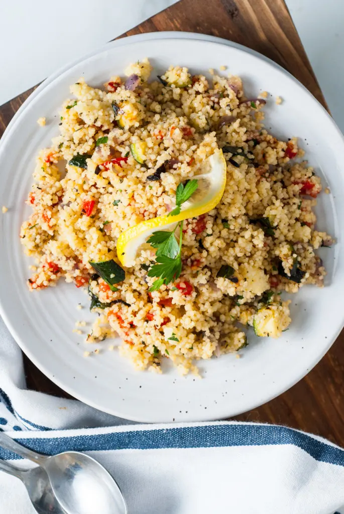 Lemon slice on top of a plate of couscous.