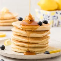 Syrup being drizzled over pancakes.