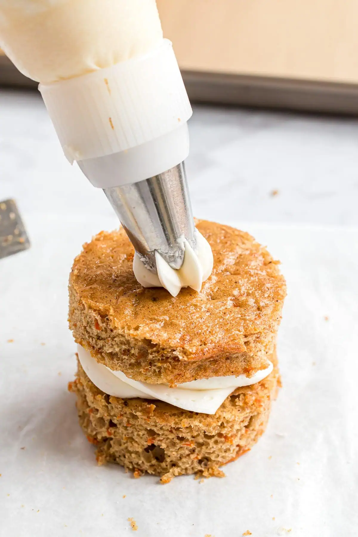 Second layer of cream cheese frosting being added to cake.