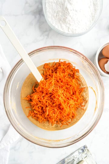 Shredded carrots added to a large bowl.