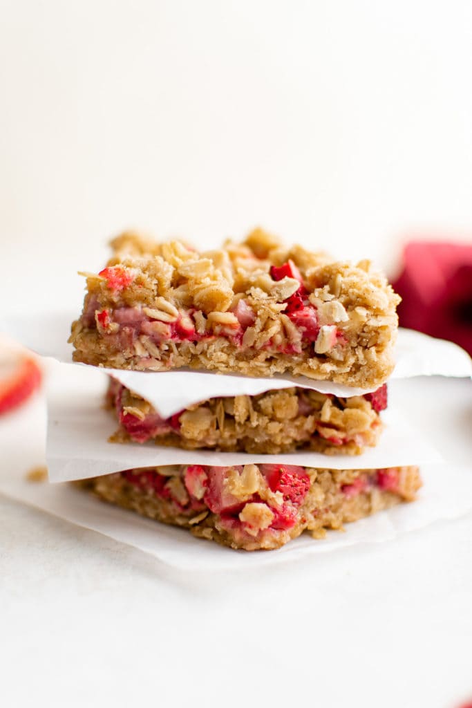Three strawberry oatmeal bars in a stack.