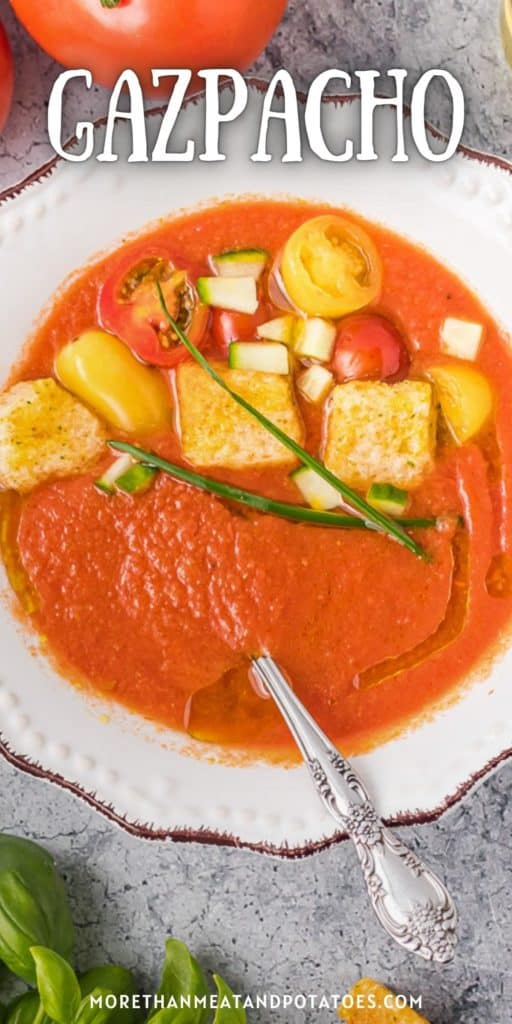 Close up view of a bowl of gazpacho with toppings.