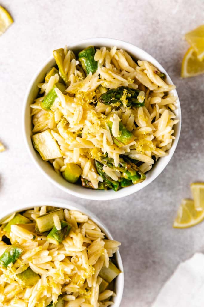 To down view of bowls of orzo with lemon asparagus.
