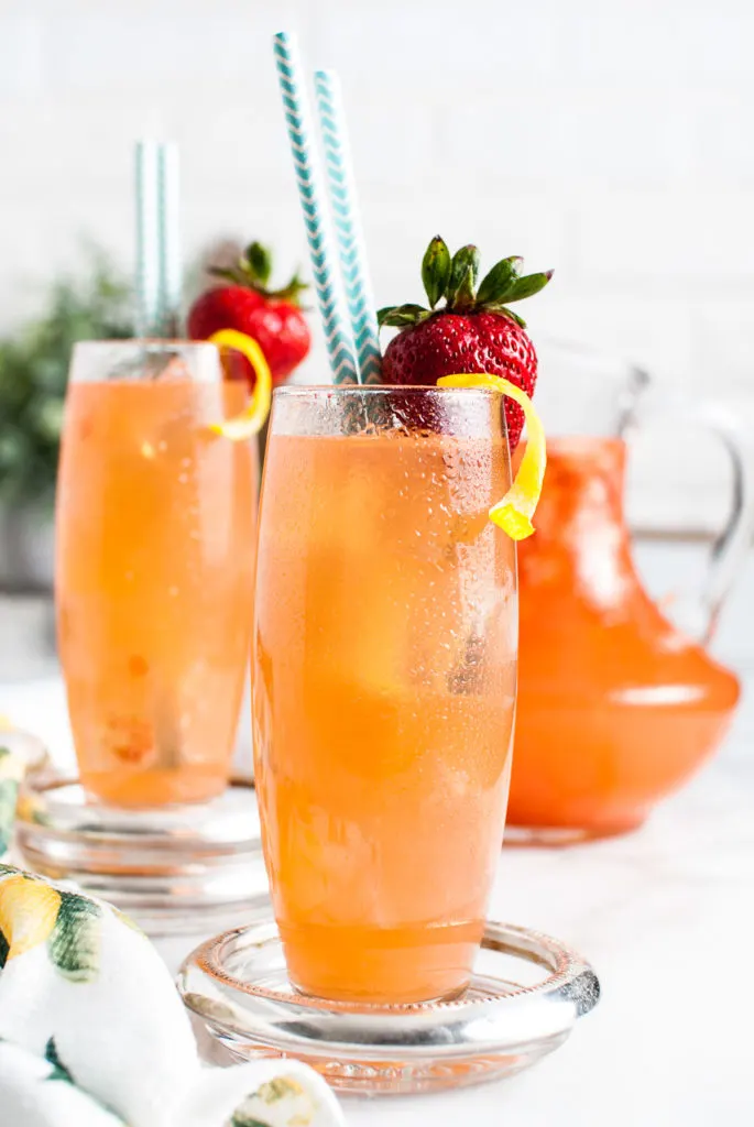 Two glasses filled with guava flavored lemonade.