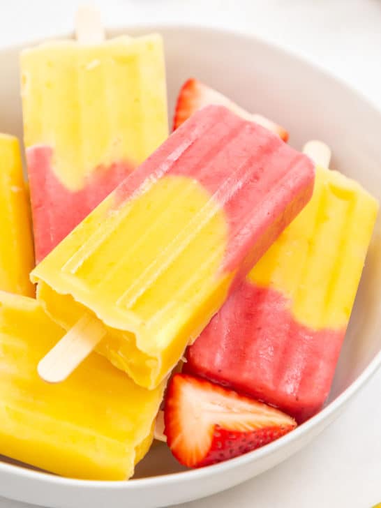 Large bowl filled with fruit popsicles.