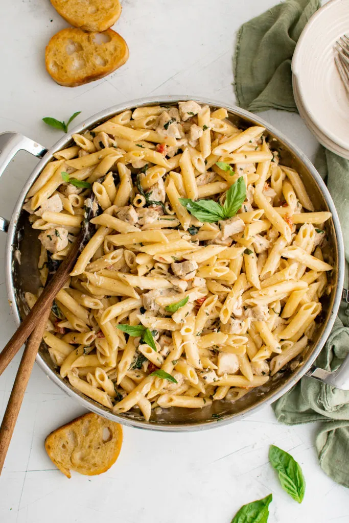 Top down view of Tuscan chicken pasta in a skillet.