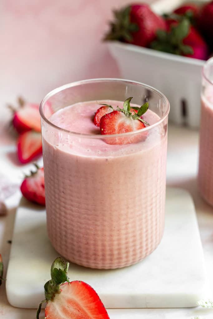 Strawberries on top of a smoothie.