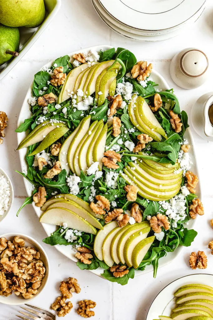 Pear slices on top of an arugula salad.