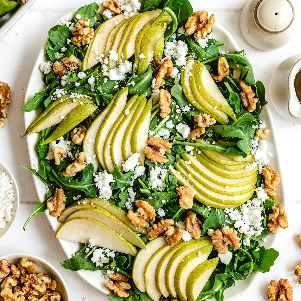 Top down view of an arugula salad with pear slices.