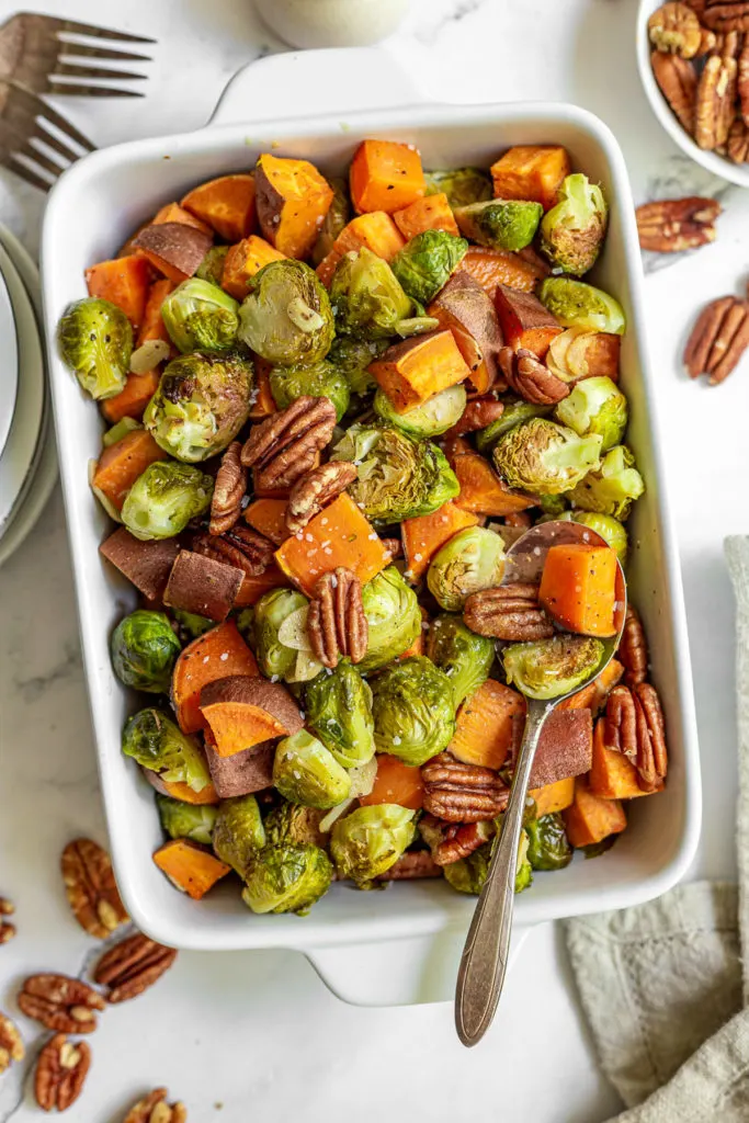 Top down view of brussel sprouts and sweet potatoes in a dish.