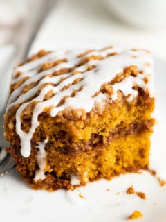 Close up view of a slice of pumpkin coffee cake on a plate.
