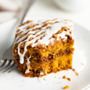Close up view of a slice of pumpkin coffee cake on a plate.