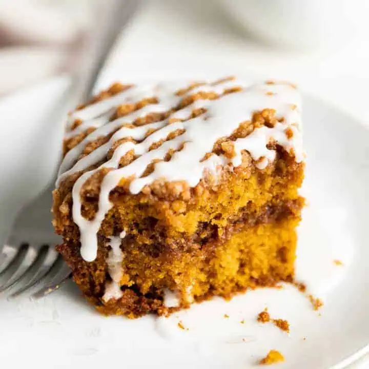 Close up view of a slice of pumpkin coffee cake on a plate.