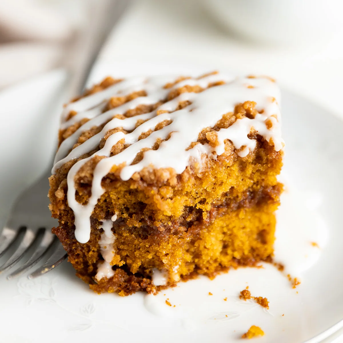 Close up view of a slice of pumpkin coffee cake on a plate.