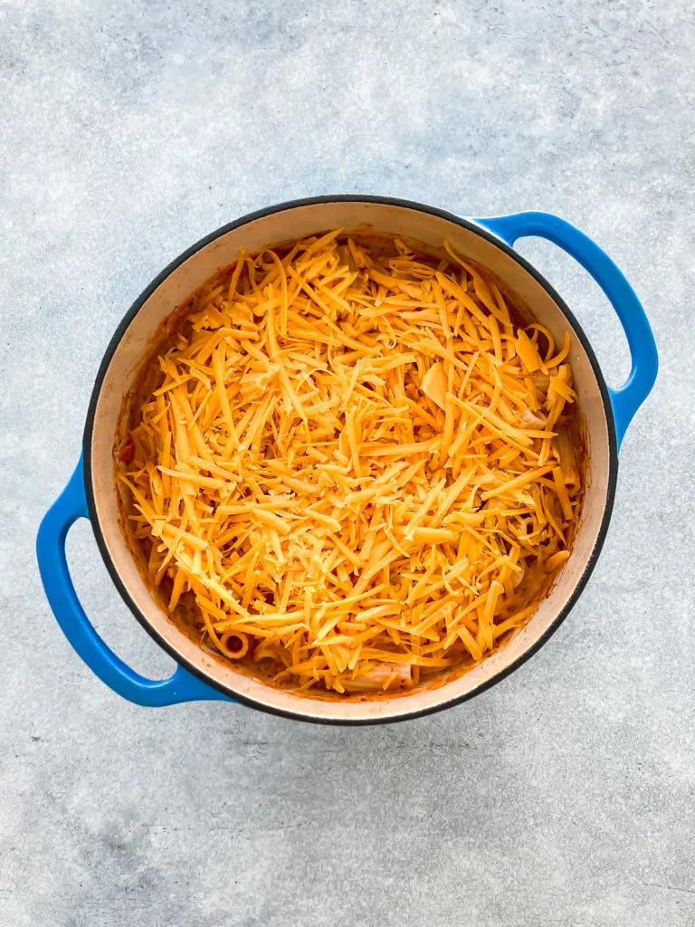 Shredded cheddar cheese on pasta.