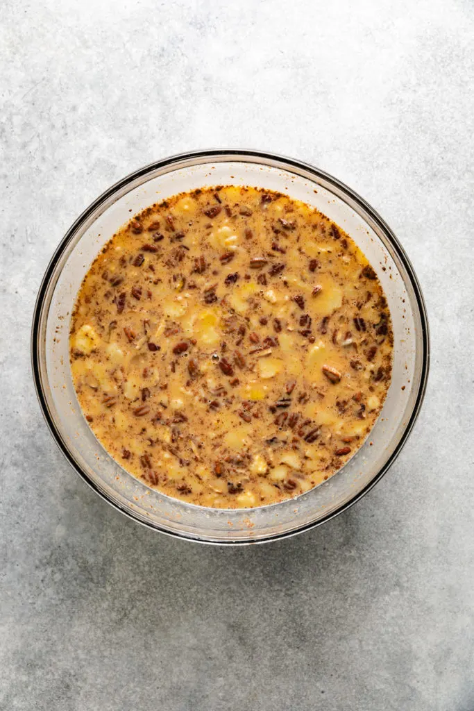 Filling for bread pudding stirred in a bowl.