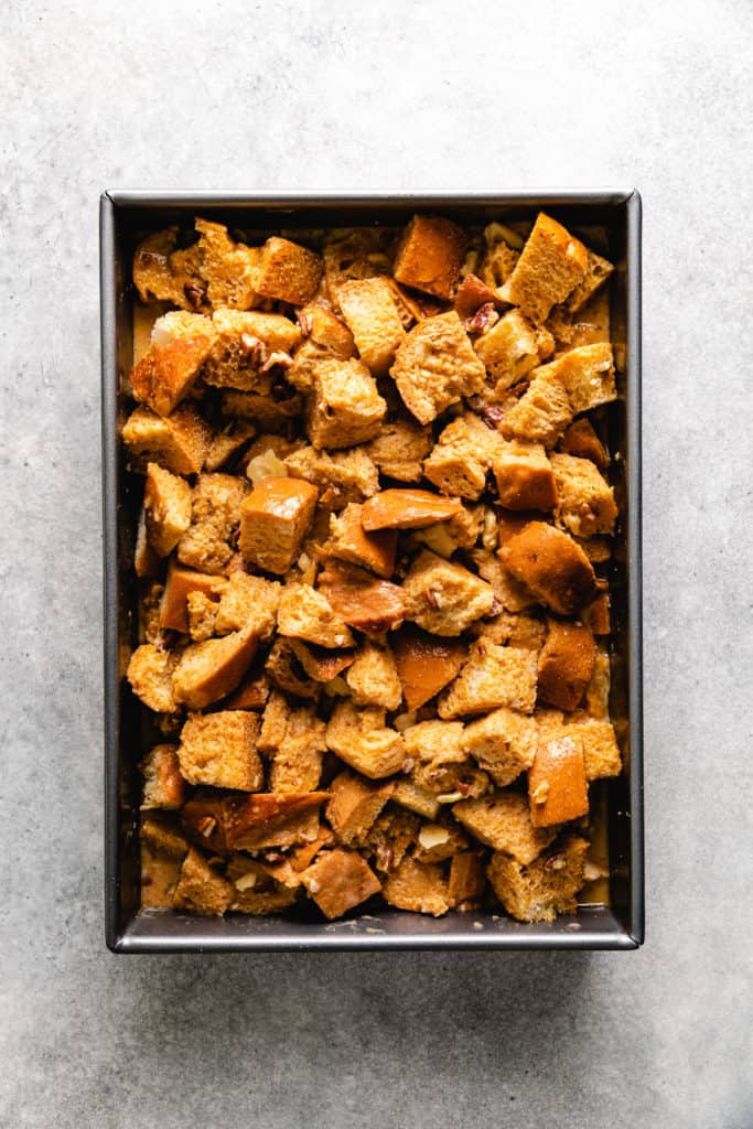 Unbaked pumpkin bread pudding in a baking pan.
