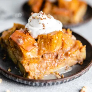 Close up view of a slice of bread pudding with creamy sauce.