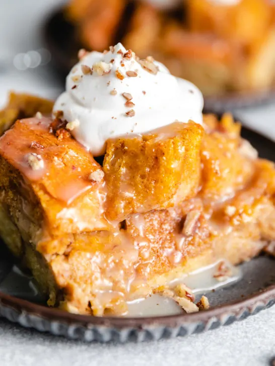 Close up view of a slice of bread pudding with creamy sauce.