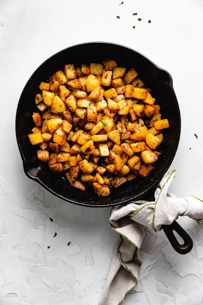 Cast iron skillet filled with skillet potatoes.