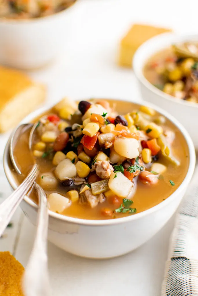 Bowl of 7 can soup with spoons.