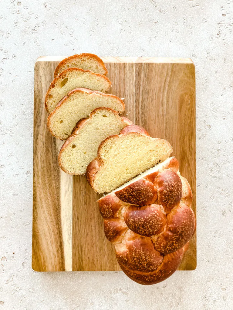 Sliced challah bread on a cutting board.