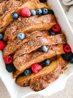 Close up view oven baked toast and fruit in a baking dish.