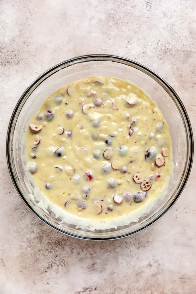 Bowl of bread batter with cranberries and nuts.