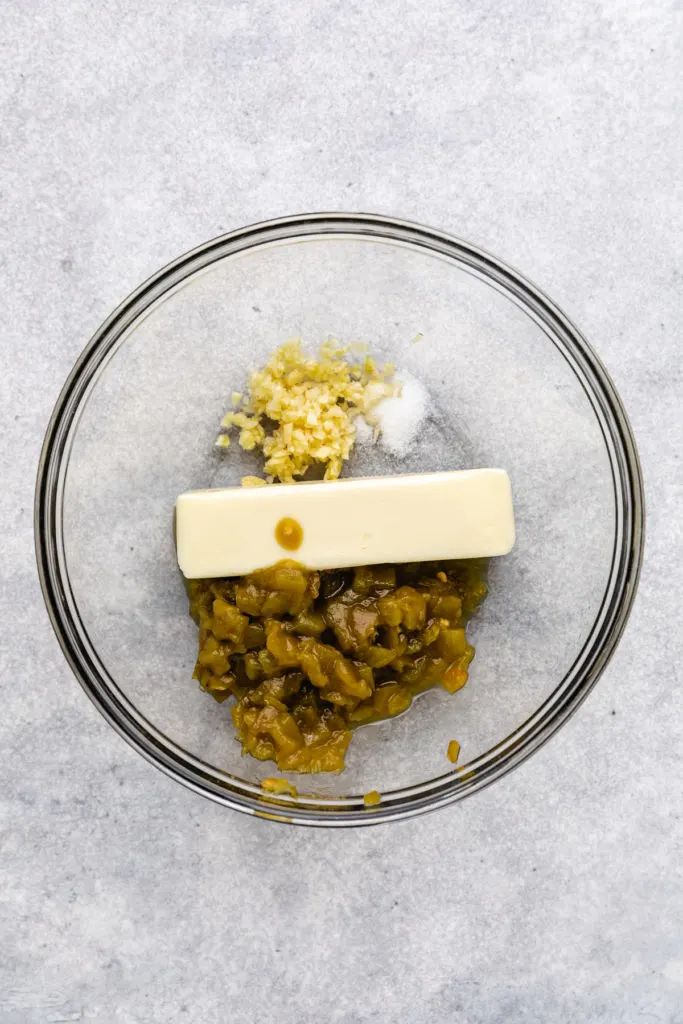 Butter, garlic, green chiles and salt in a glass bowl.