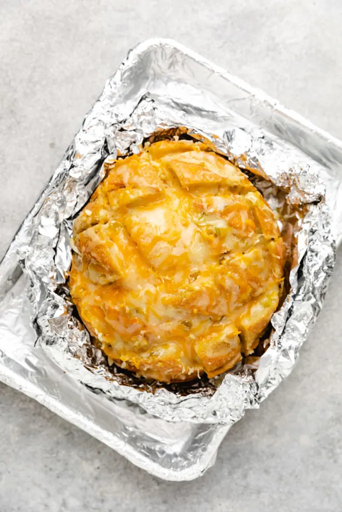 Loaf of cheesy bread in foil.