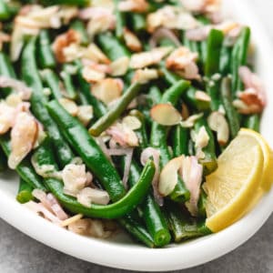 Close up of a plate of green beans with almonds.