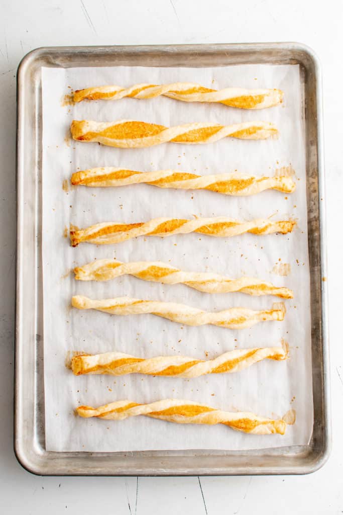 Baked cheese straws on a baking sheet.
