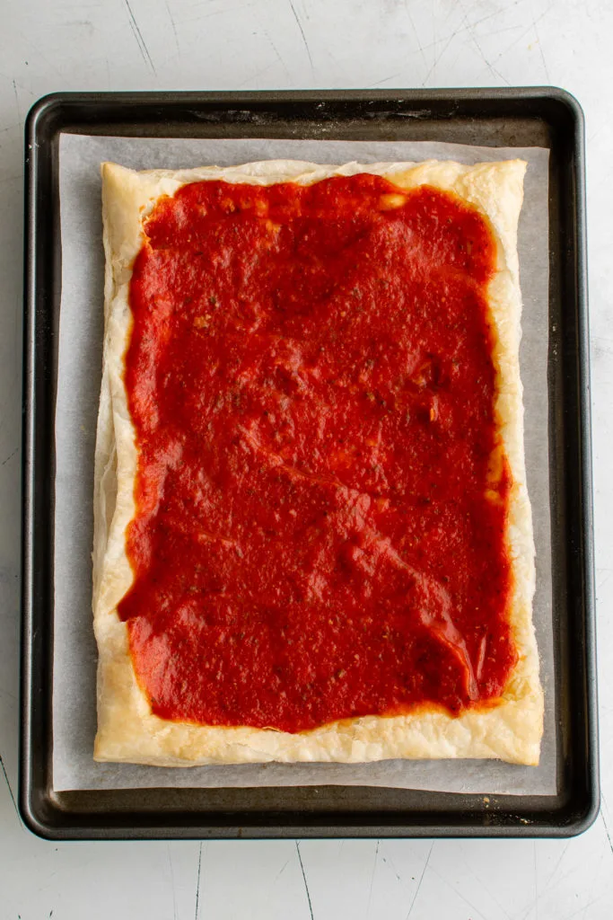 Pizza sauce on puff pastry.