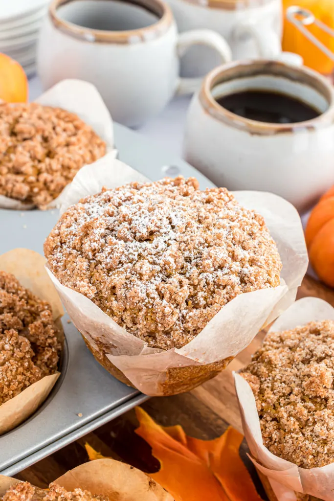 Close up view of a muffin in paper with streusel.