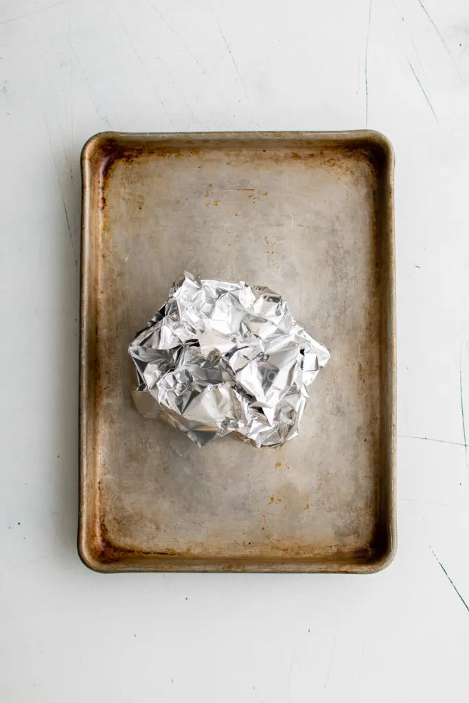 Ball of foil holding garlic.