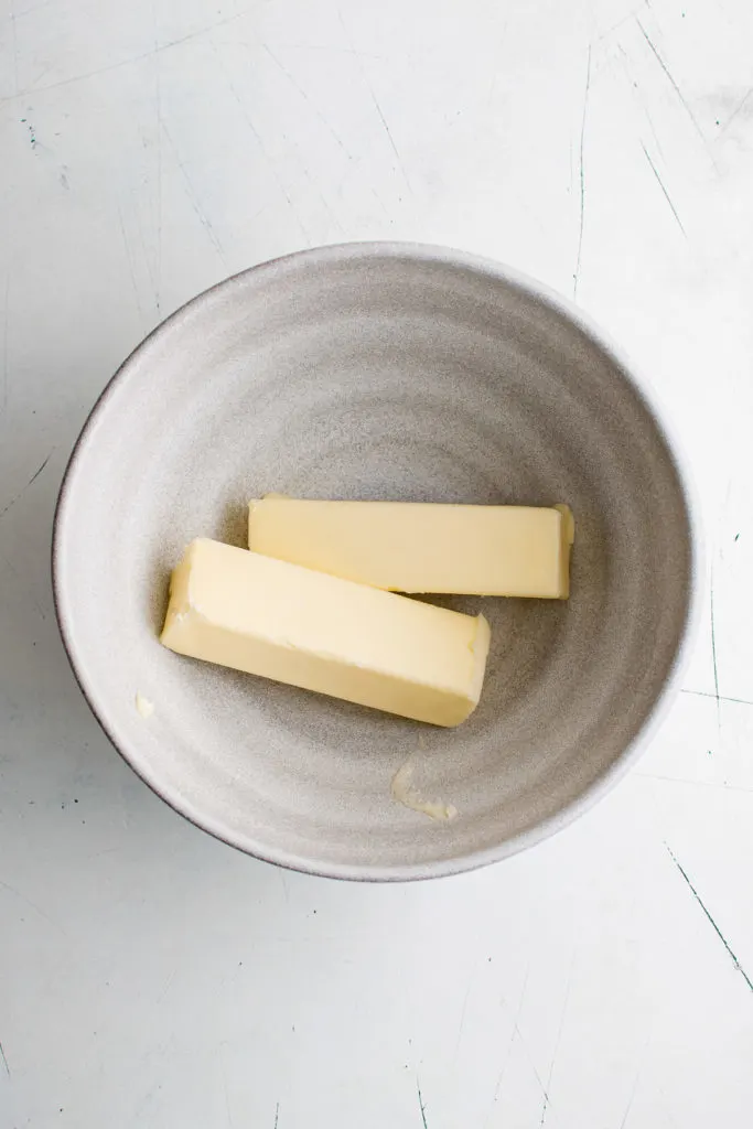 Two sticks of butter in a bowl.