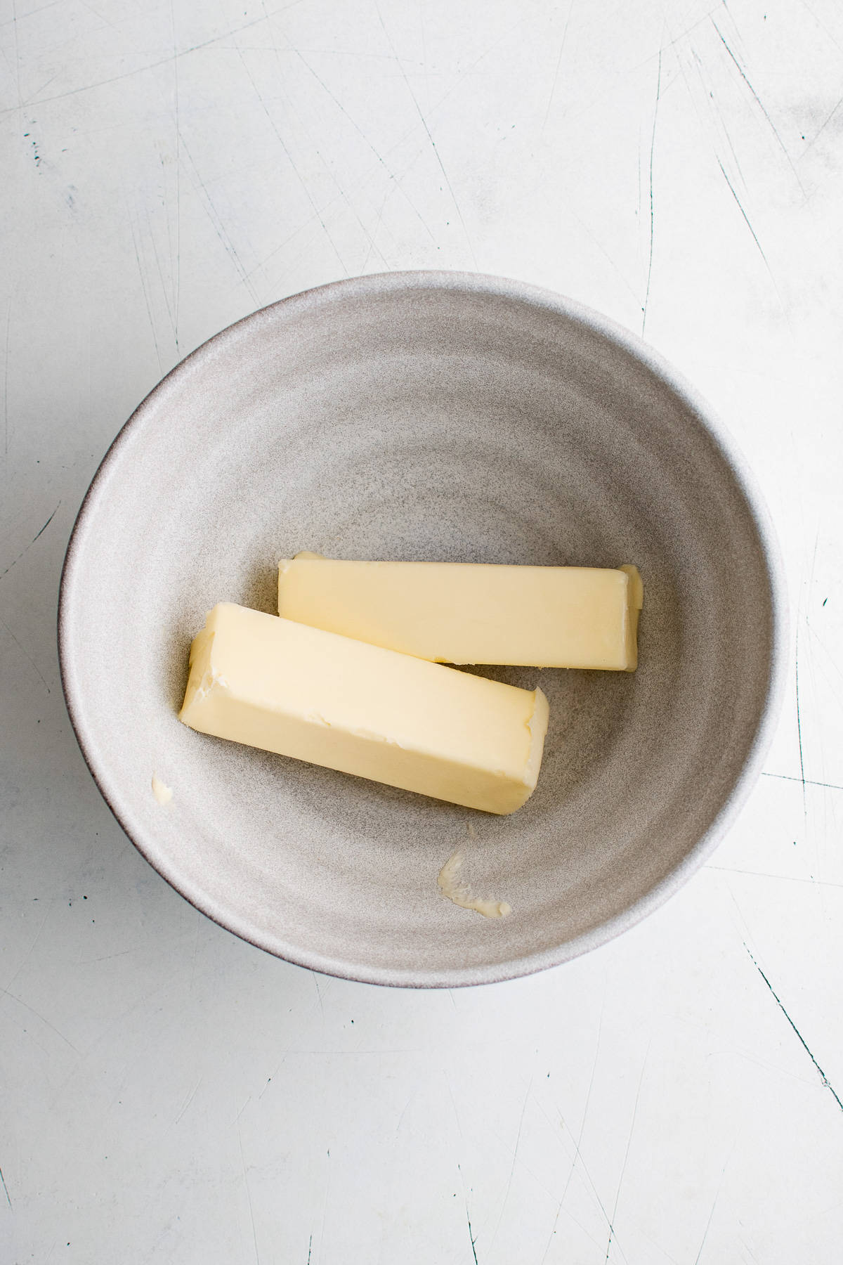 Two sticks of butter in a bowl.