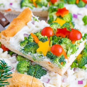 Close up view of a slice of christmas veggie pizza.