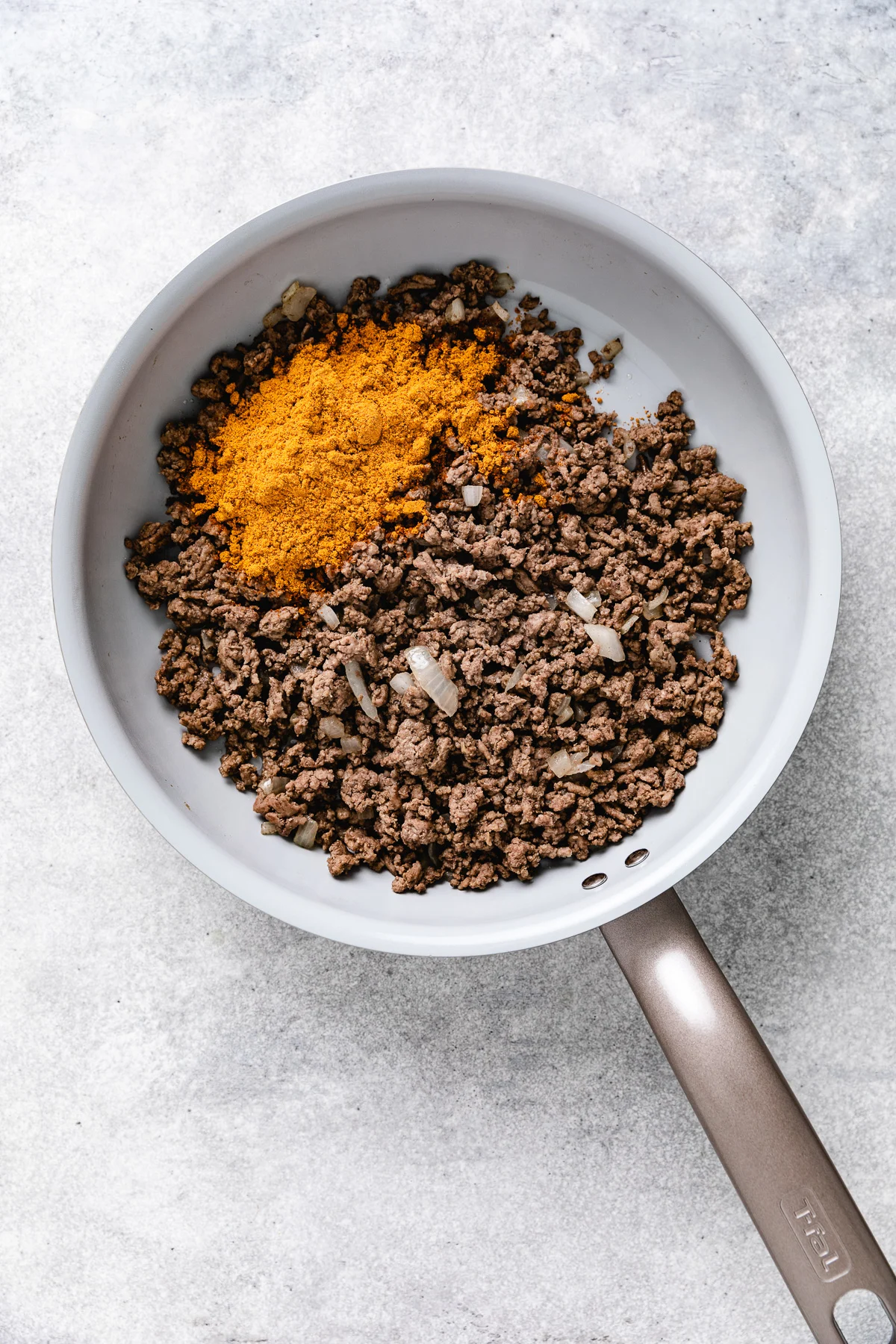 Taco seasoning and ground beef in a pan.