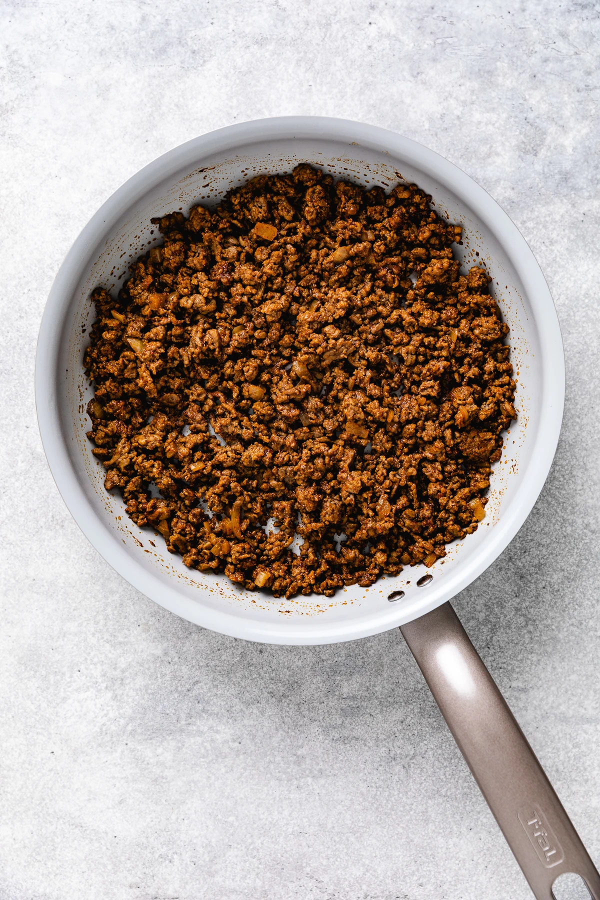 Seasoned ground beef in a pan.