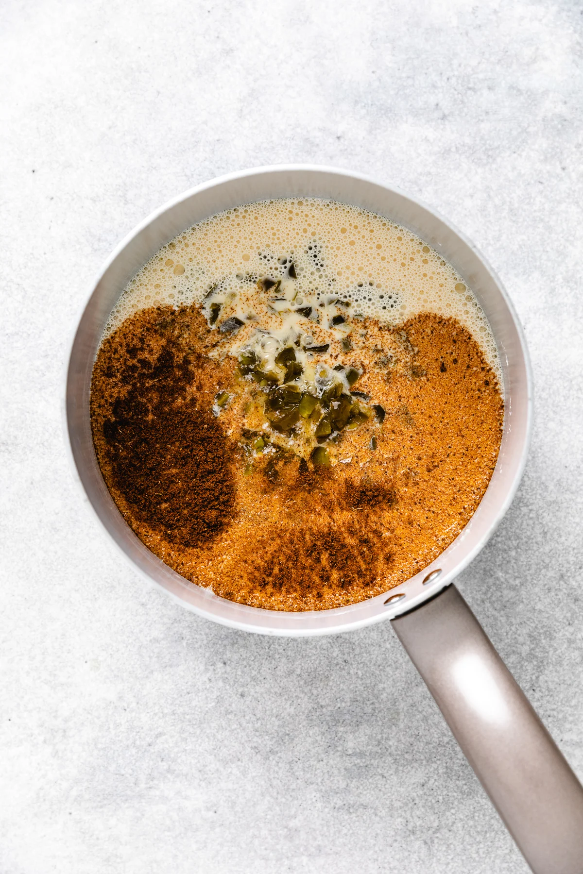 Seasonings in a pan of green chiles.