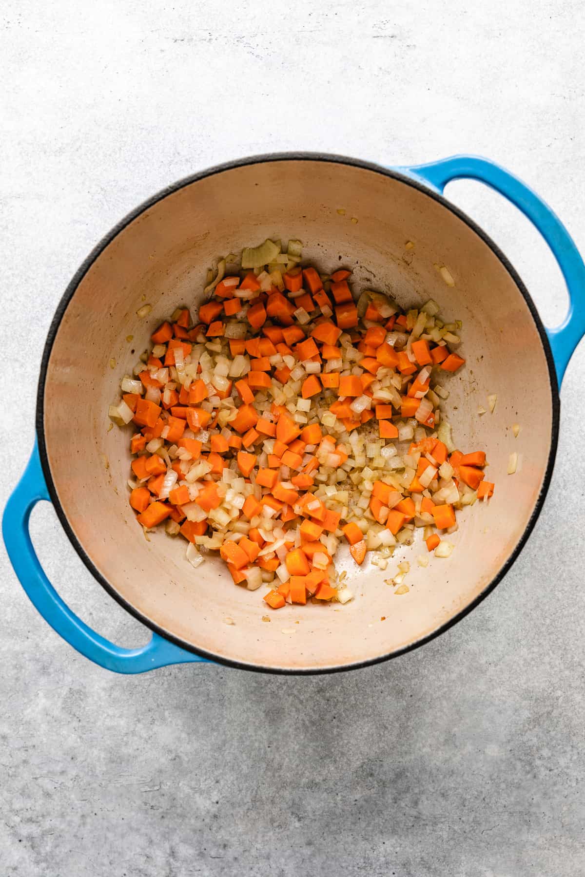 Sauteed carrots and onions in a pan.