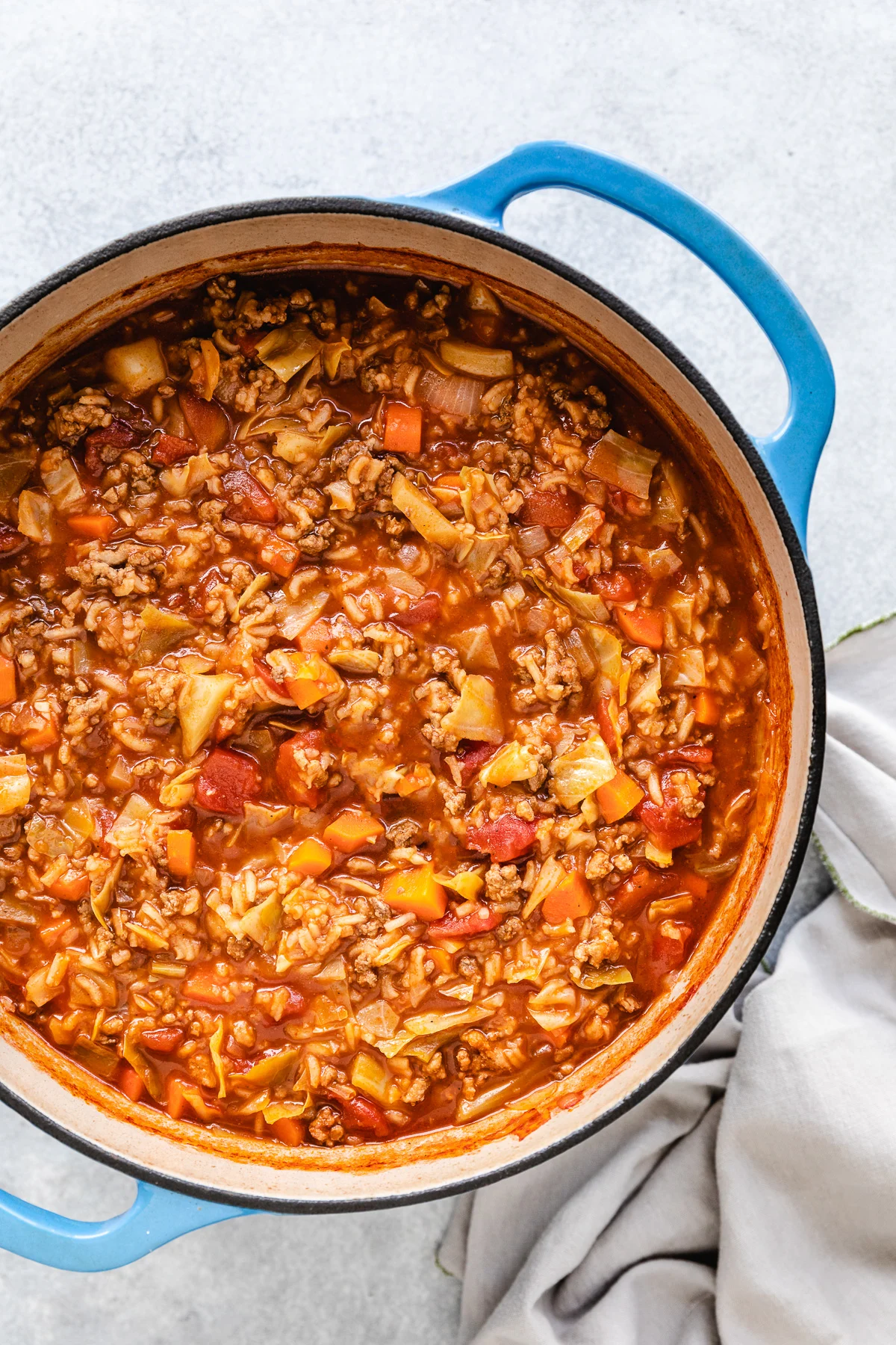 Top down view of cabbage and rice soup in a pan.