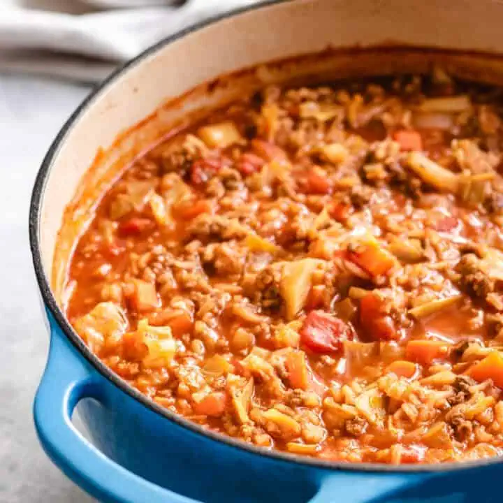 Close up view of cabbage roll soup in a blue pan.