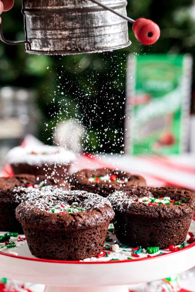 Powdered sugar being dusted over brownies.