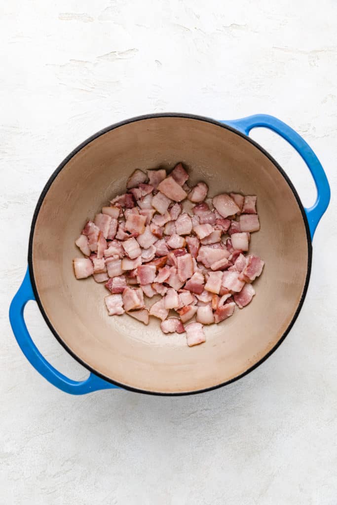 Bacon cooking in a Dutch oven.
