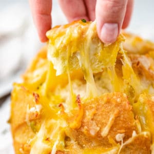 Close up view of a piece of cheesy pull apart bread.