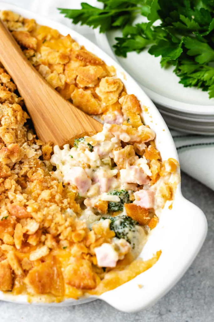 Side view of a spoon in a ham casserole.